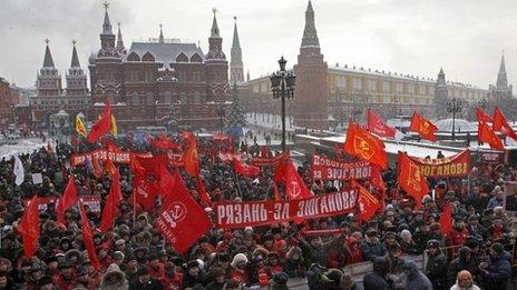 Communist party supporters hold red flags as they take part in a rally protesting alleged vote rigging in Russia's elections