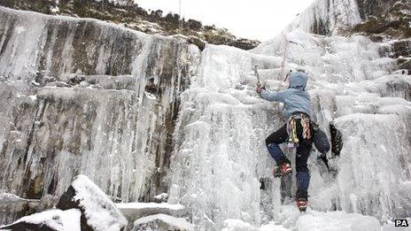 An ice climber at a frozen waterfall in the Brecon Beacons