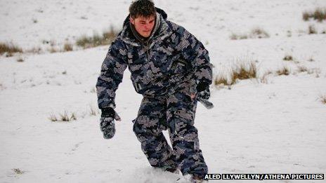 A young man snowboards on Pen y Fan in the Brecon Beacons, Powys