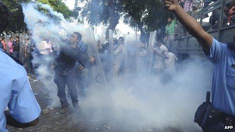 Maldivian police are seen amid a cloud of tear gas as they confront the military in Male in this handout photograph provided by Haveeru News Service