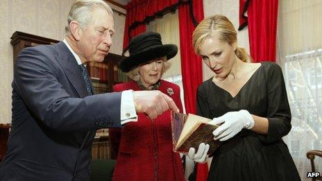 The Prince of Wales, the Duchess of Cornwall and actress Gillian Anderson examine a first edition of one of Dickens's novels