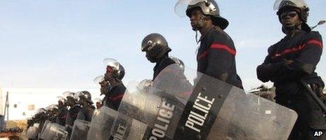 Riot police stand guard over Place de l"Obelisque in Dakar, Senegal, where hundreds of people gathered to protest the decision by the country's highest court to allow President Abdoulaye Wade to run for a third term in February's election