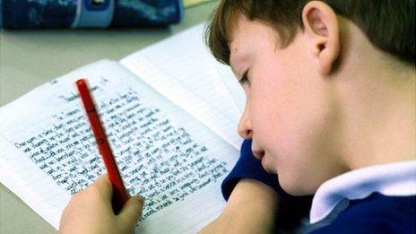 Primary school pupil writing in a classroom