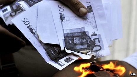 Man burning 50 euro notes (actually photocopied notes)