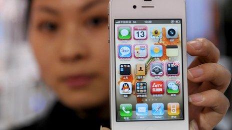 A woman holds her iPhone 4 in Hangzou, China 13 January 2012