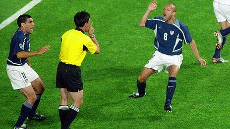 US midfielder Claudio Reyna (L) and US forward Earnie Stewart (R) protest to referee Lu Jun of China (C) about a disallowed goal early in their Group D match against Poland at the 2002 FIFA World Cup in Daejeon on 14 June 2002