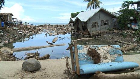 Logs, debris and a damaged house in Iligan