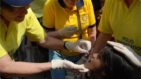 Rotary volunteers immunise child in India