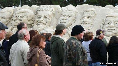 People in South Carolina look at sand sculpture depicting Republican presidential candidates (L-R): Mitt Romney, Newt Gingrich, former candidate Jon Huntsman, Rick Perry, Rick Santorum and Ron Paul