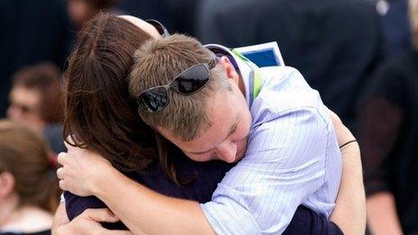 Families who lost loved ones hold each other during a remembrance service in Hagley Park in Christchurch on 22 February, 2012, the first anniversary of a 6.3 earthquake that killed 185 people