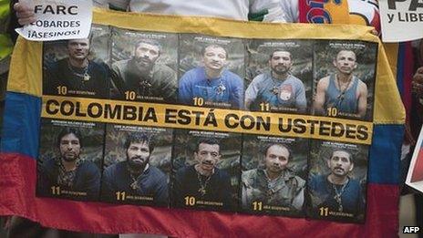 A man holds a banner with pictures of the ten Colombian police and military officers still held captive as hostages of the Farc in a demonstration in December 2011