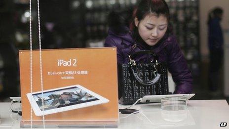 A customer tries out at an iPad at a retailer in Chongqing