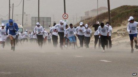 People compete in the Gaza marathon in strong winds