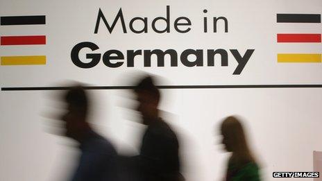 People walk past a sign saying 'made in Germany'