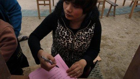 A villager fills out ballot at a voting booths in Wukan