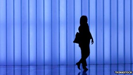 Business woman with bag against modern light wall blue