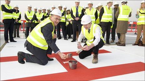 Hospital trust chief executive Andrew Morris and Adam Wells, construction director, finish painting the giant 'H' on the new helipad at Frimley Park Hospital