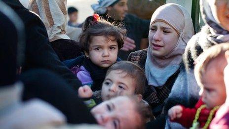 A family leaves their house after the building was hit by a Syrian Army tank in Idlib, north Syria