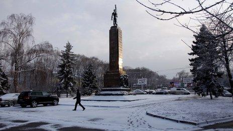 A man walks past a statue in Chisinau, Moldova (March 6, 2012)