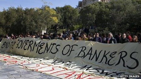 Leftist demonstrators hold a banner at the entrance to the Acropolis archaeological site, reading in English: 'End the governments of bankers'