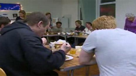 Homeless people being served food at a church in Swansea