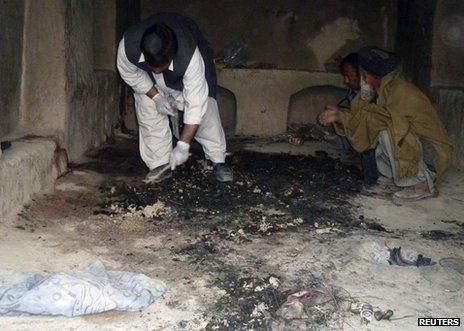 An Afghan man examines the scene of one of the attacks in Kandahar, 11 March