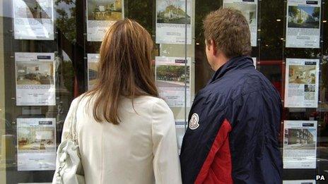 Couple looking in estate agent window