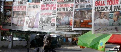 A man reads newspapers after the first results from Senegal's controversial presidential election indicate a tight race between incumbent Abdoulaye Wade and former Prime Minister Macky Sall at a newsstand in central Dakar on 27 February 2012