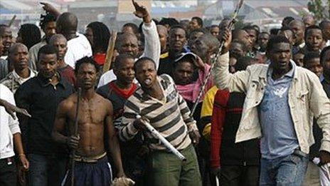 A crowd, armed with clubs, machetes and axes on a rampage on May 20, 2008 during xenophobic clashes at Reiger Park, south of Johannesburg