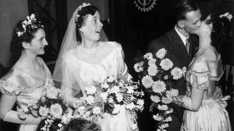 Groom kisses bridesmaid at 1950s wedding