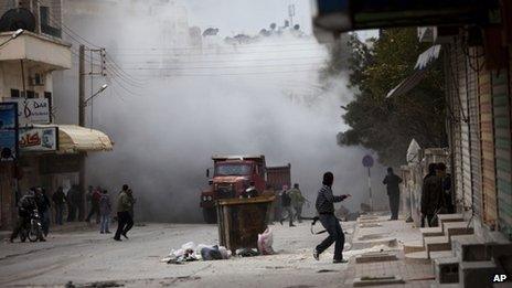 Free Syrian Army fighters are seen amid smoke during a day of fierce fighting with government forces in Idlib, March 10 2012