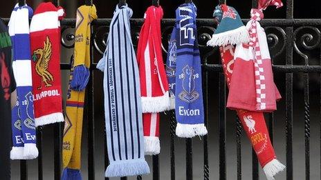 The scarves of several football clubs are seen on the gates during a service at Anfield football stadium in Liverpool, north west England on April 15, 2008