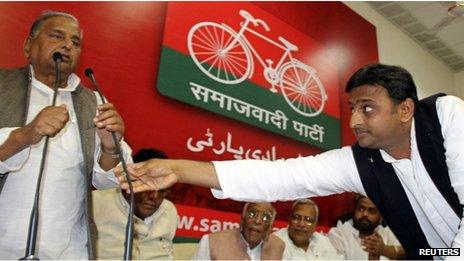 Akhilesh Yadav (R), the chief minister-designate of the northern Indian state of Uttar Pradesh and state party president adjusts microphone for his father, the Samajwadi Party President Mulayam Singh Yadav