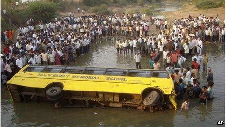 Indians gather near a school bus that fell into a pond near Tungaram village in Khammam district, about 250 kilometers west of state capital Hyderabad, India, Tuesday, March 20, 2012