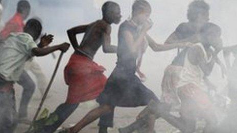 Opposition UDPS supporters run through a cloud of tear gas outside N'Djili airport in Kinshasa