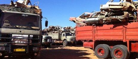 Old trucks loaded with smashed up cars