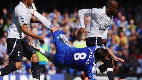 Frank Lampard falls in the penalty area under pressure from Younes Kaboul and William Gallas