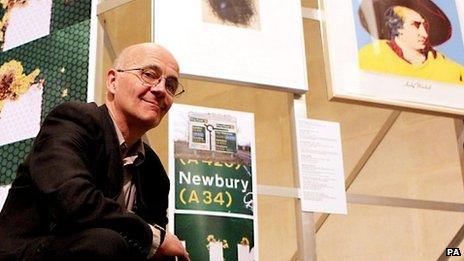 Patrick Keiller stands amongst works from the Robinson Institute Collection, an exhibition that considers the current economic crisis, at the Tate Britain