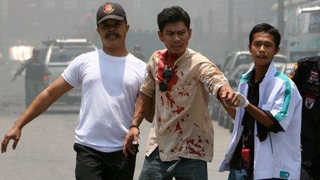 Thai rescue workers help a man injured in the blast