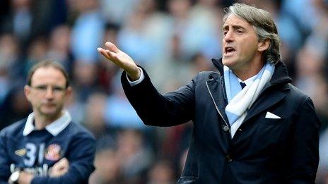 Manchester City manager Roberto Mancini (right) watches his team while Sunderland's Martin O'Neill looks on