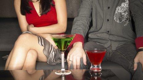 Man and woman sitting next to each other with drinks in front of them