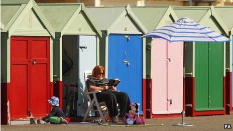 A woman outside beach huts