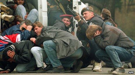 People shelter from Serb sniper in Sarajevo, 1992