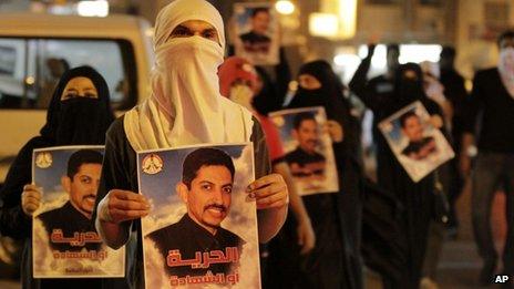 Bahraini anti-government protesters carry images of jailed hunger-striker Abdulhadi al-Khawaja during a demonstration outside the Interior Ministry in Manama (8 April 2012)