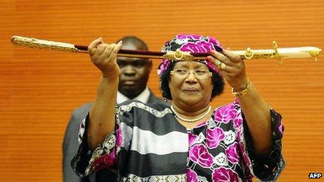 The President of Malawi, Joyce Banda, holds a ceremonial sword as she is sworn in