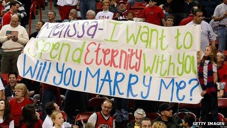 A fan holds up a banner bearing a wedding proposal at a basketball game between the Arizona Wildcats and the UNLV Rebels in 2008