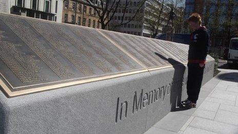 A child looks at a plaque in Belfast which features the names of those who died when the Titanic sank