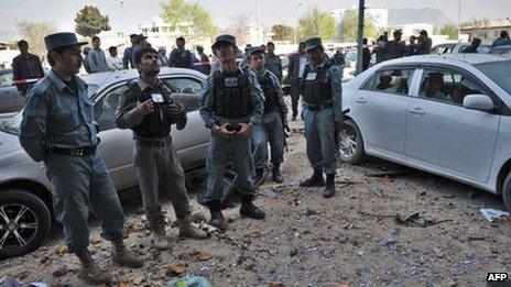 Afghan police officers stand guard outside the building where Taliban fighters launched an attack in Kabul, on April 16, 2012