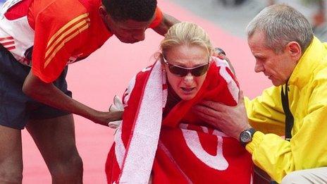 Haile Gebrselassie (L) and chief organiser Wolfgang Konrad (R) help Paula Radcliffe