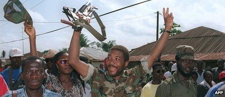 Charles Taylor (C) jubilates on 21 July 1990 with his rebel troops in Roberts Field after taking over the position from Liberian government troops